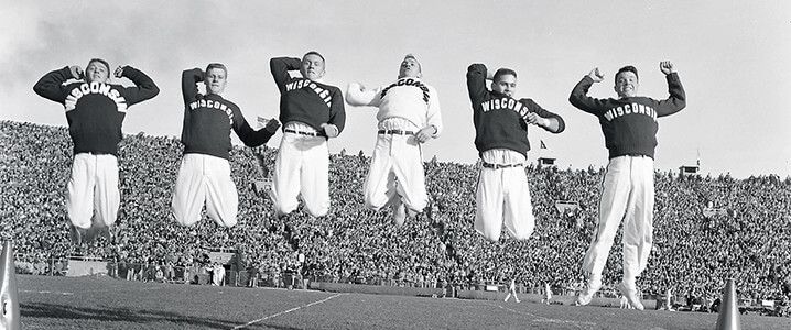 Male cheerleaders jumping at Badger Football game.