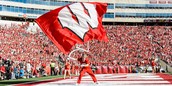 Flag-waving cheerleader on the field at Camp Randall during a home football game