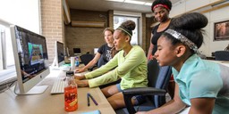 High school students Chane Skinner (center in green) and Micah Edwards-Sopha (far right) work with PEOPLE mentors Caitlin Iverson (left) and Shaya Glass (standing) to program video games during a Gaming for Girls  Pre-College Enrichment Opportunity Program for Learning Excellence (PEOPLE) workshop in Witte Residence Hall at the University of Wisconsin-Madison on July 1, 2014. (Photo by Bryce Richter / UW-Madison)
