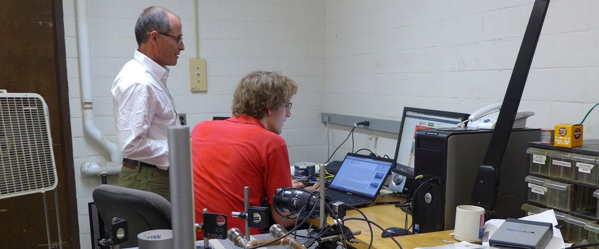 Prof. Duncan Carlsmith and a student work on a problem.