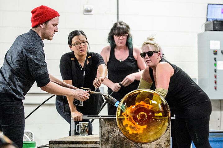 From left to right: Joey Zeller, Helen Lee, Suzy Peterson, and Heather Sutherland work to inflate Madisonís largest glass ornament during a UW Glass Lab event in the Art Lofts Building at the University of Wisconsin-Madison on Dec. 11, 2014. The public event featured students from the UW Mad Gaffer team performing a number of interesting glass experiments and working together to create a giant Christmas ornament that was auctioned off for charity. (Photo by Bryce Richter / UW-Madison)
