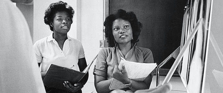 Two African-American female students with their professor.