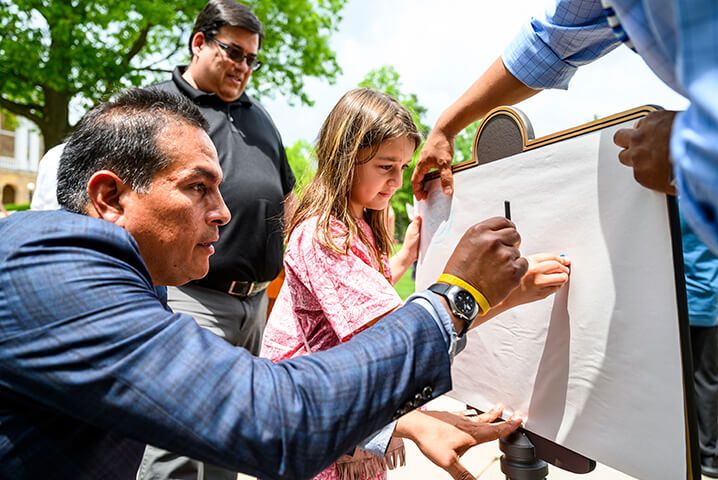 Aaron Bird Bear (left), assistant dean for Student Diversity Programs, helps Demetria Abangan-Brown Eagle (right) to create a crayon rubbing on paper during a heritage marker dedication ceremony for the "Our Shared Future" plaque on Bascom Hill at the University of Wisconsin-Madison on June 18, 2019. The “Our Shared Future” plaque makes clear that the university occupies ancestral Ho-Chunk land and will serve to educate the campus community members and campus visitors. (Photo by Bryce Richter /UW-Madison)