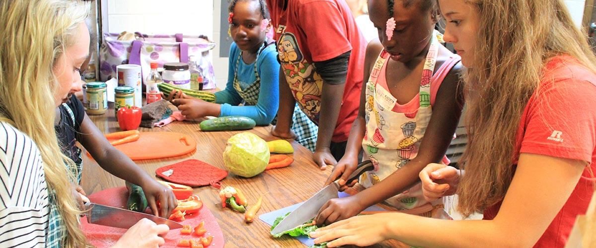 UW–Madison students showings kids how to chop food