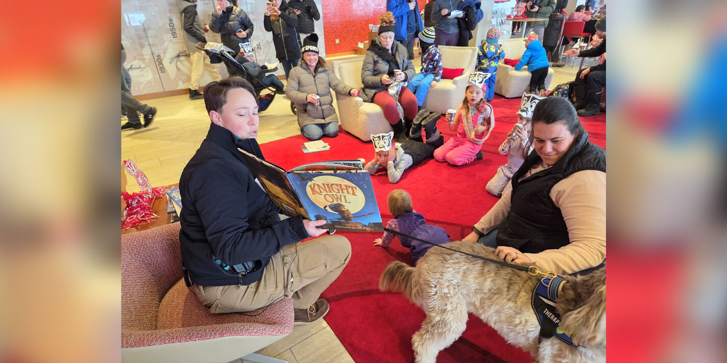 Adult reading a book to a a room of children