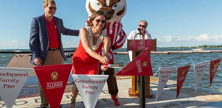 Mary Sue Goodspeed Shannon ’81 cuts the ribbon and officially dedicates the Goodpseed Family Pier. The pier is the first major element of Alumni Park to be completed. Mary Sue’s husband, Mike Shannon ’80, is pictured on the left, and WAA president and CEO Paula Bonner MS’78 is at the podium on the right.