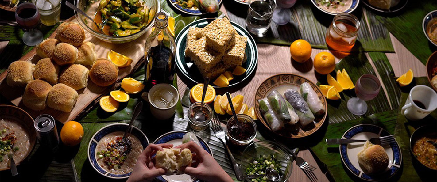 Filipino food and banana leaves laid out on a table.