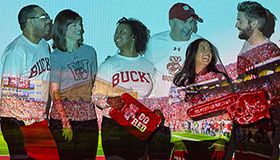 Alums smiling and laughing with Camp Randall stadium projected on them.