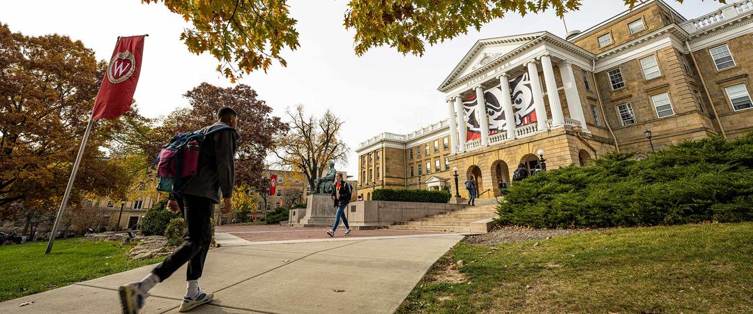 Student walking up Bascom Hill with Bascom Hall shown in the background.